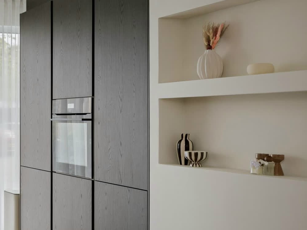 Hoge kastenwand in donker fineer met inbouwoven, in een keuken die wij plaatsten in Deventer