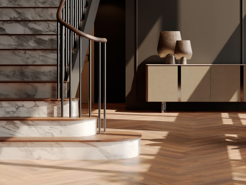 Ronde trap en een dressoir op een warme, goudkleurige visgraatvloer van Room5 Executive Gold in de zon