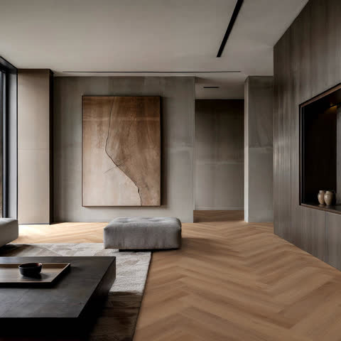 Woonkamer met een betonnen wand en een lage tafel op een lichte visgraatvloer van Room5 Superior Beige