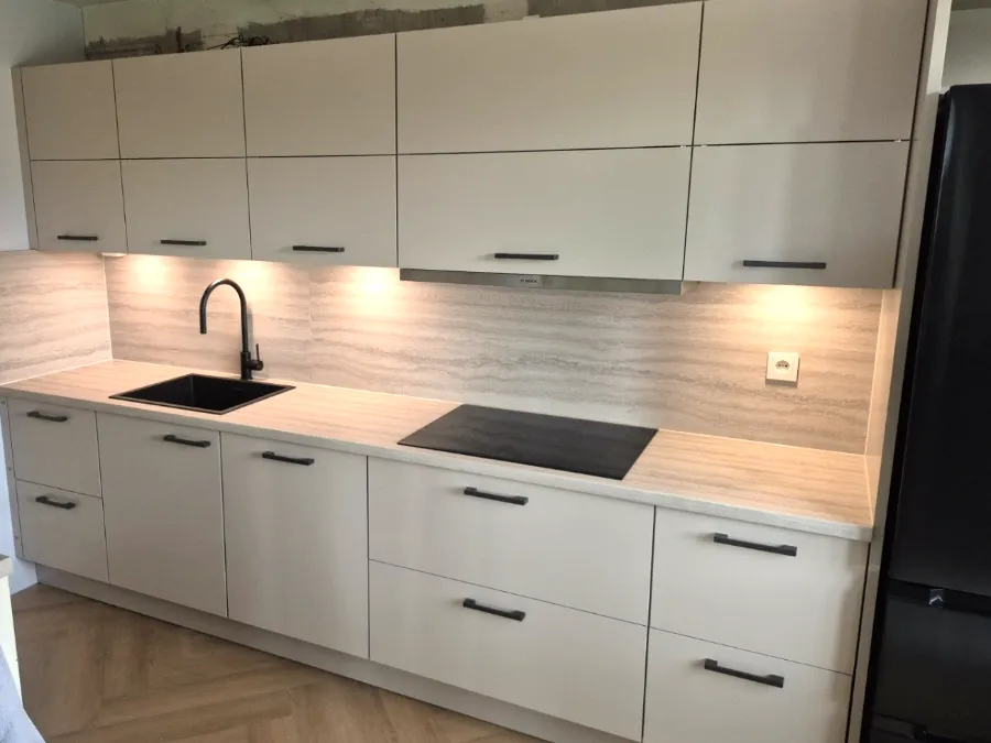 Lichtgrijze keuken met houtlook achterwand en verlichting