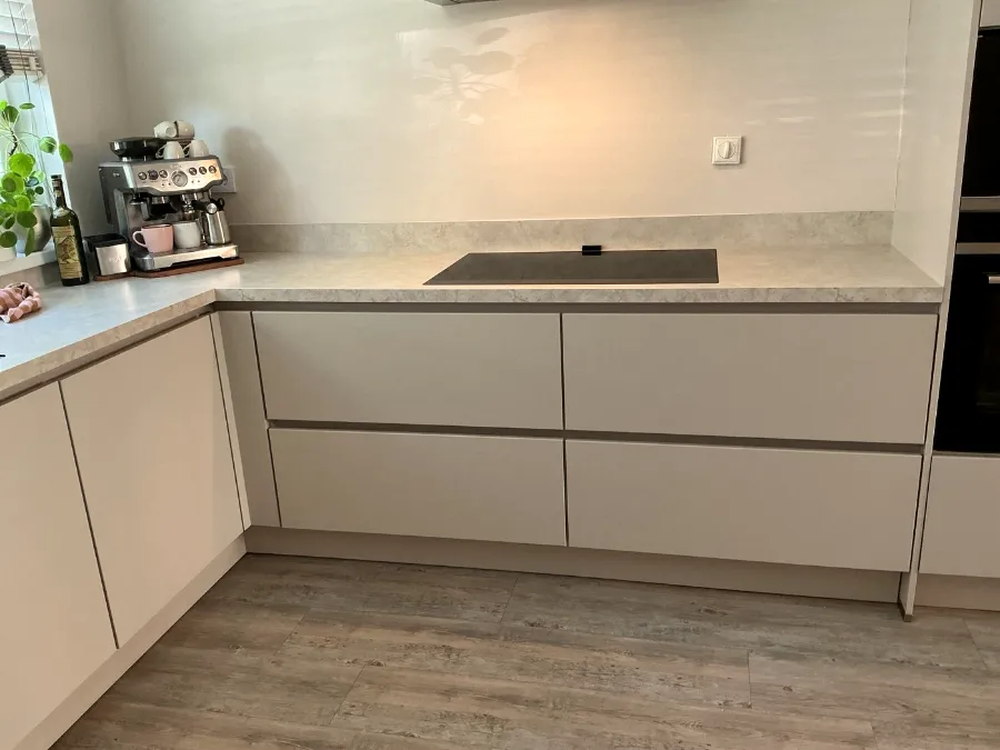 Lichte greeploze U-keuken met nieuwe deuren en lades