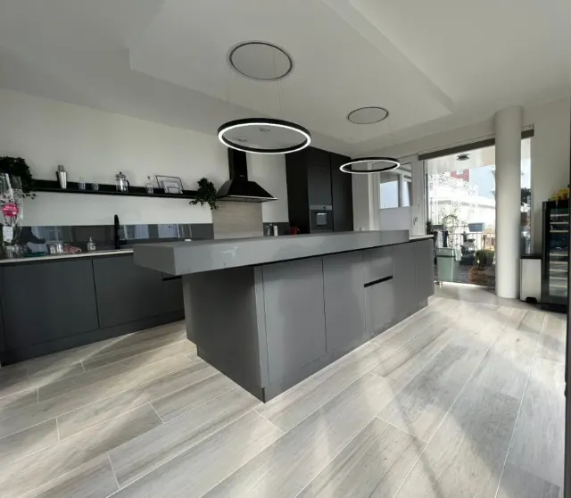 Overzicht van de leefkeuken met de ronde lampen boven het eiland
