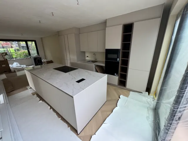 Kookeiland met marmerlook blad en een kastenwand erachter