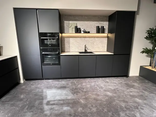 Showroomkeuken met matzwarte hoge kasten en een verlichte nis