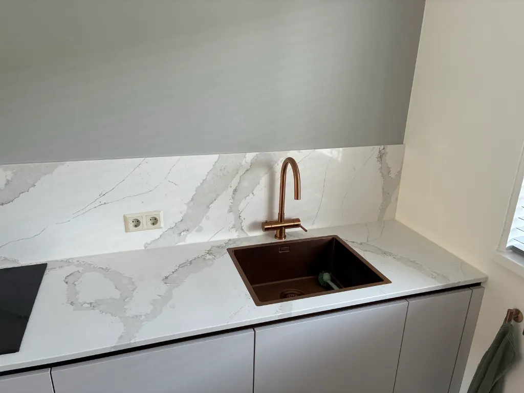 Koperen spoelbak in het marmerlook werkblad