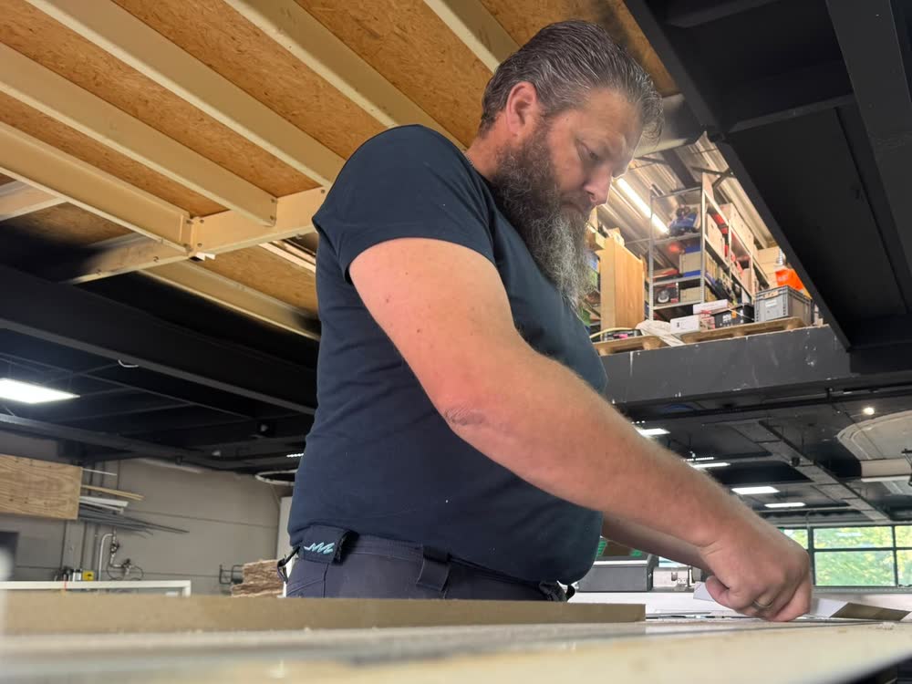 Een gezaagd onderdeel wordt op de zaagtafel in de werkplaats nagekeken